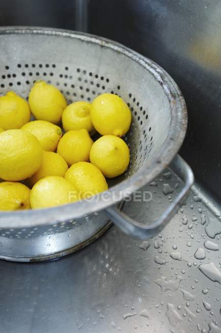 Frisch gewaschene Zitronen im Sieb — Stockfoto