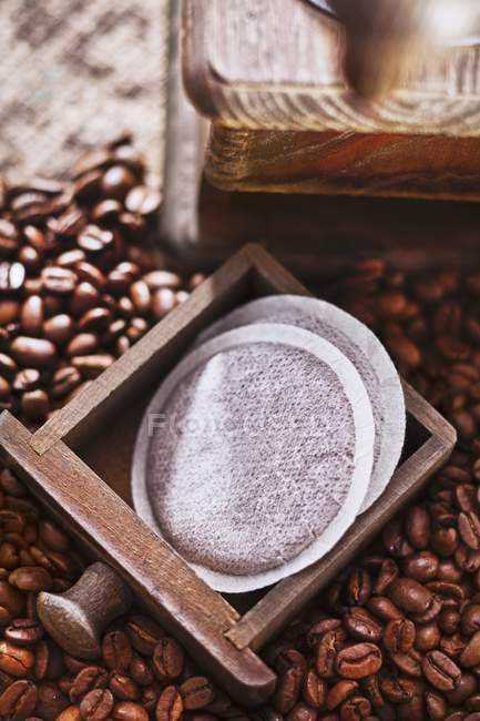 Coffee pads with mill and beans — Stock Photo