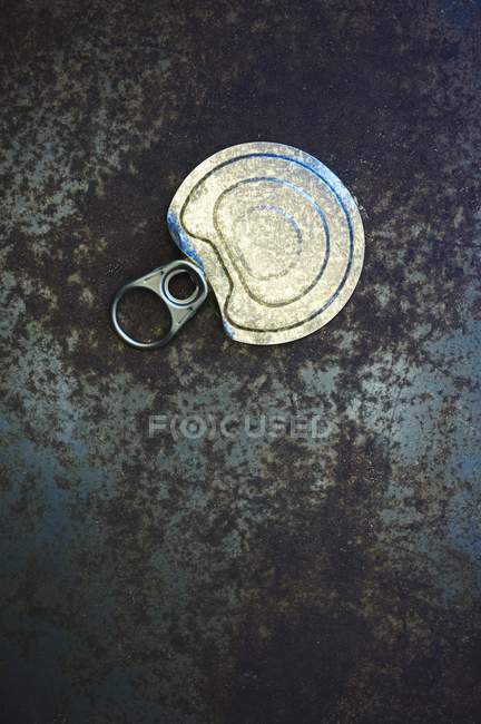 One pull top from a can on rusty metal surface — Stock Photo