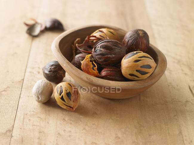 Целые мускатные орехи с чашей — стоковое фото