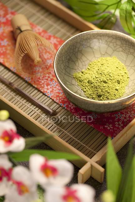 Vue rapprochée du thé vert Matcha japonais en poudre dans un bol sur un plateau — Photo de stock