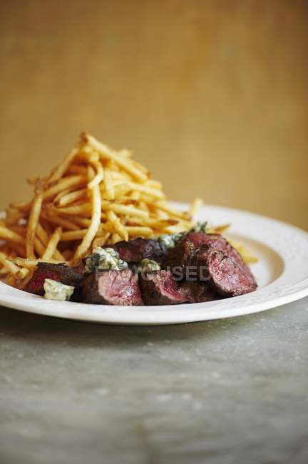 Bistecca affettata con patatine fritte — Foto stock