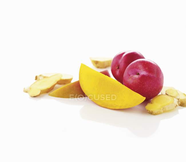 Plums with mango and ginger slices — Stock Photo