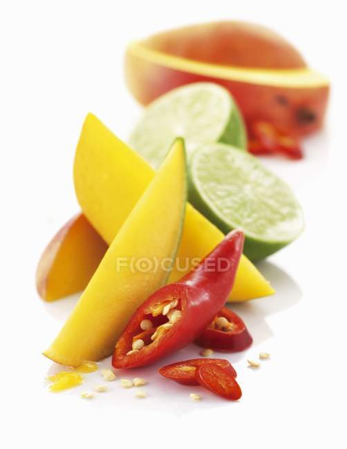 Tranches de mangue avec des citrons verts et des piments — Photo de stock