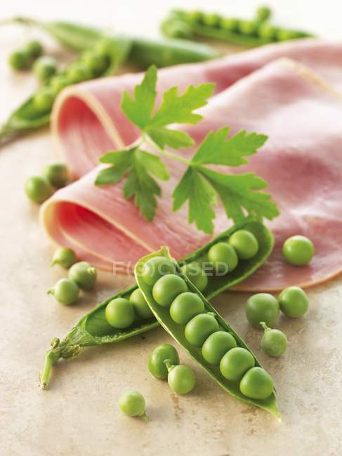 Peas and boiled ham slices — Stock Photo