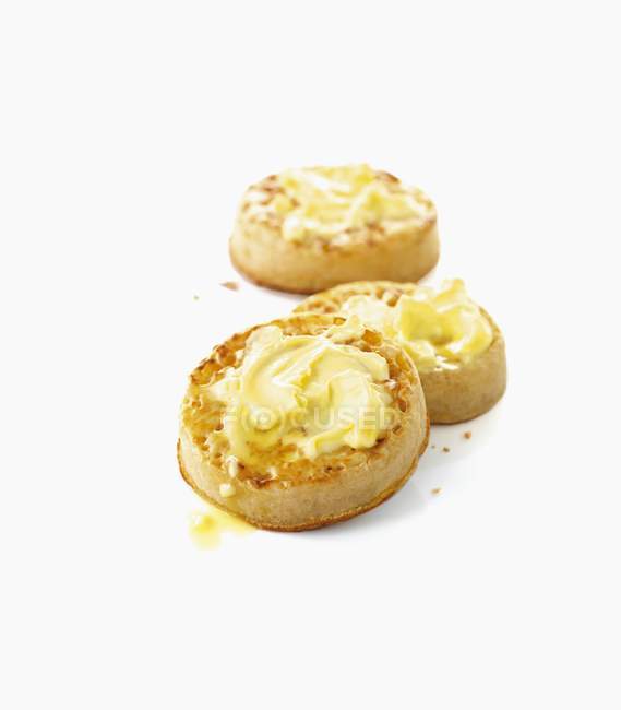 Closeup view of crumpets with butter on white surface — Stock Photo