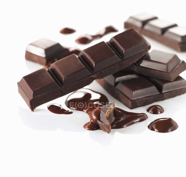 Куски и расплавленный шоколад — стоковое фото