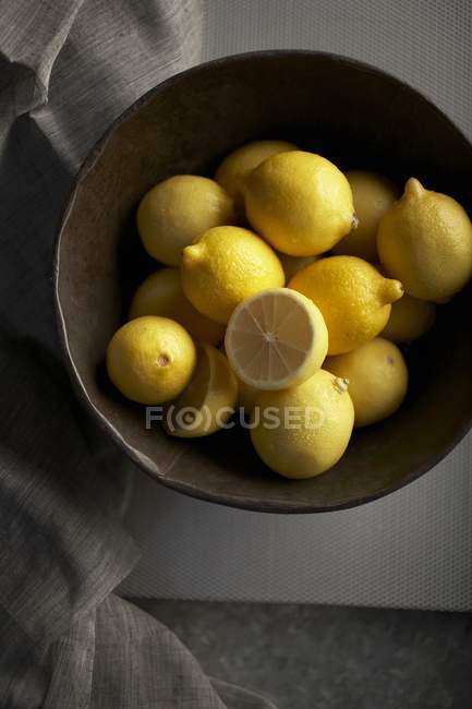 Спелые лимоны в деревянной чаше — стоковое фото