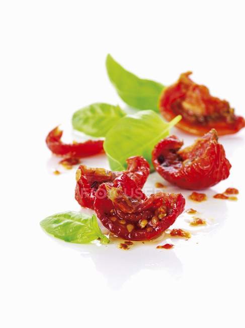 Dried tomatoes and fresh basil — Stock Photo