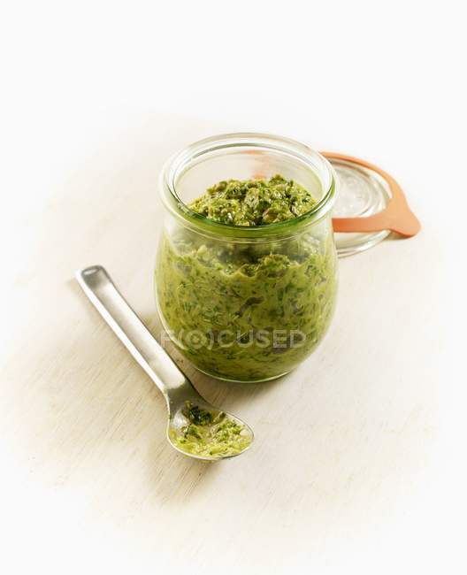 Vista elevada de la Salsa Verde casera en un frasco y en una cuchara - foto de stock