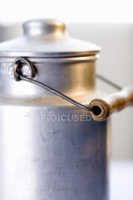 Vista close-up de uma lata de leite com tampa e cabo de madeira — Fotografia de Stock