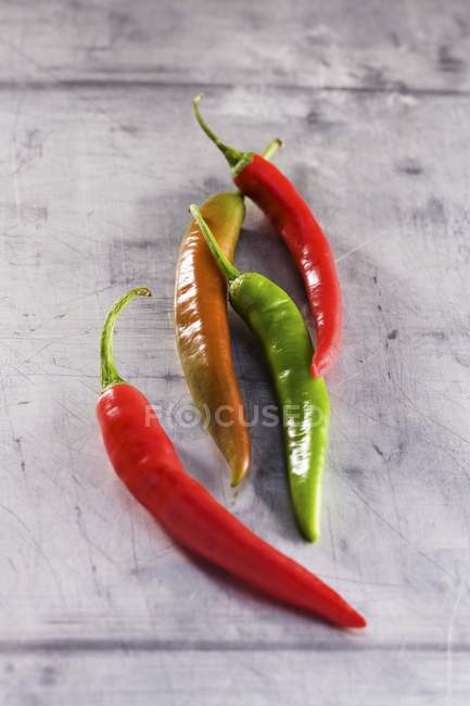 Four fresh chilli peppers — Stock Photo