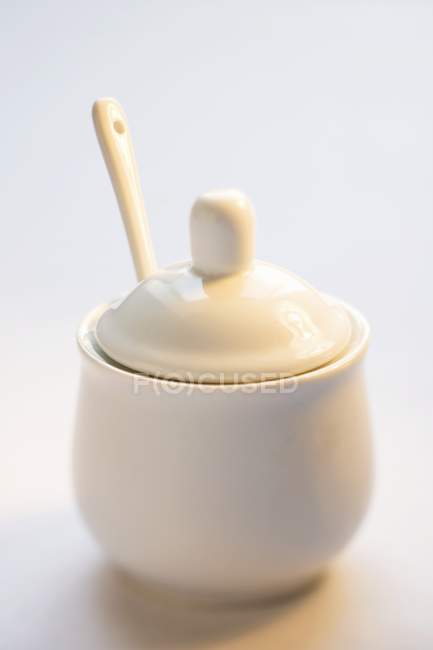 Vue rapprochée d'un pot de sucre fermé avec une cuillère — Photo de stock