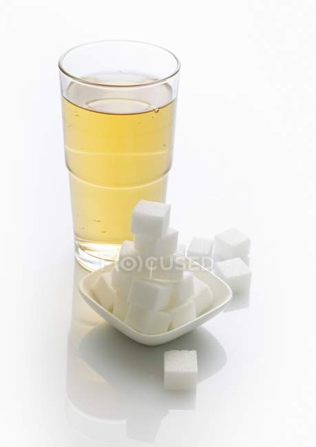 Verre de limonade et de cubes de sucre — Photo de stock