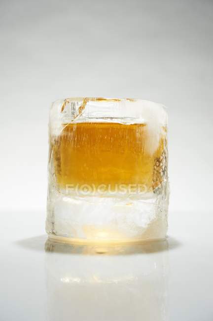 Closeup view of Scotch in ice on white surface — Stock Photo