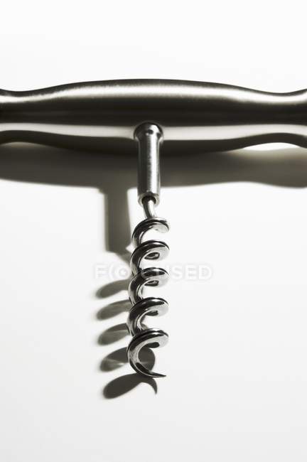 Closeup view of one silver corkscrew on white surface — Stock Photo