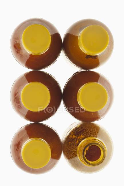 Seis botellas de aceite de palma roja brasileña sobre fondo blanco - foto de stock
