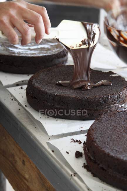 Chocolate cake being glazed — Stock Photo