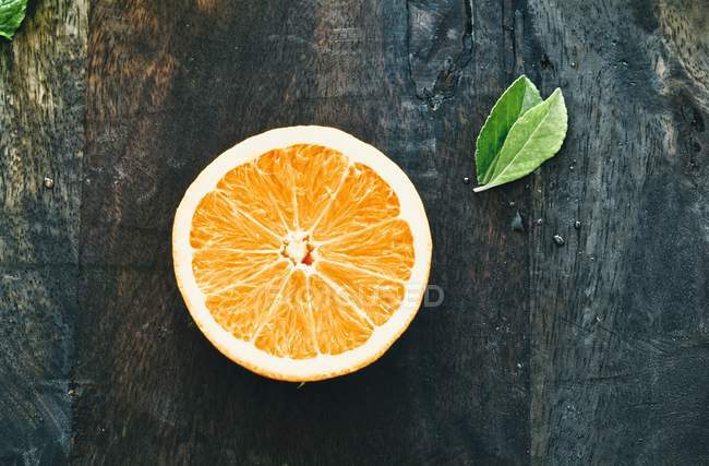 Наполовину апельсин з листям — стокове фото