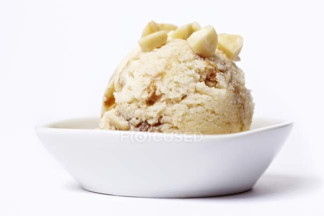 Vista close-up de sorvete com amêndoas picadas em tigela branca — Fotografia de Stock