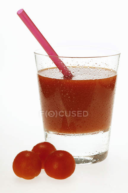 Jus de tomate en verre avec paille — Photo de stock