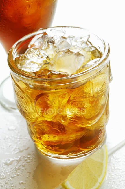 Bicchiere di tè freddo e spicchio di limone — Foto stock