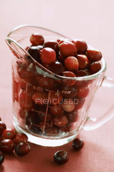 Cranberries in measuring jug — Stock Photo
