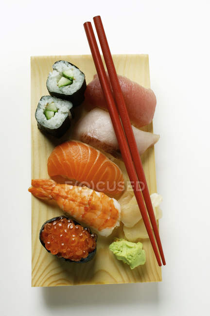 Nigiri e maki sushi em tábua de madeira — Fotografia de Stock