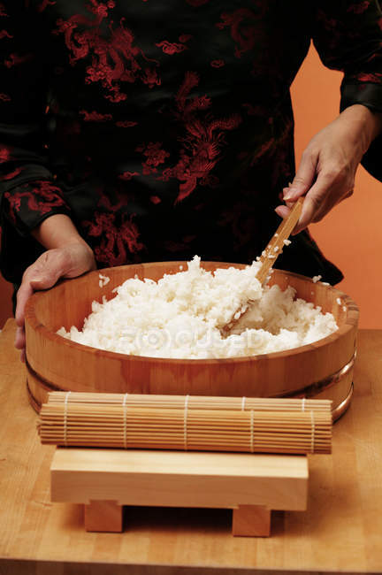 Mujer revolviendo arroz de sushi - foto de stock