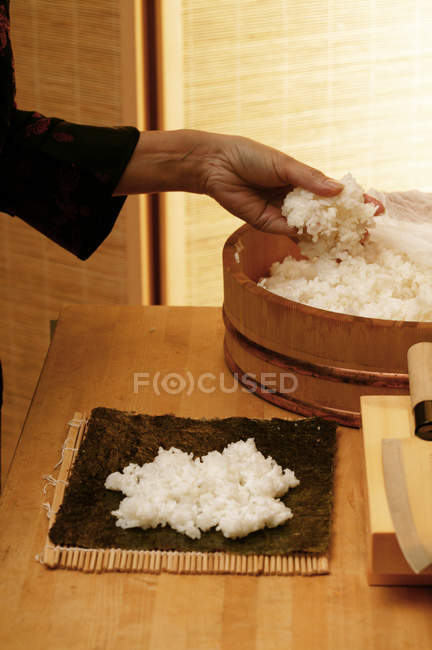 Жінка кладе рис на норі — стокове фото
