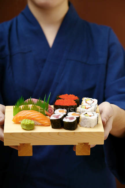 Donna che serve sushi set — Foto stock