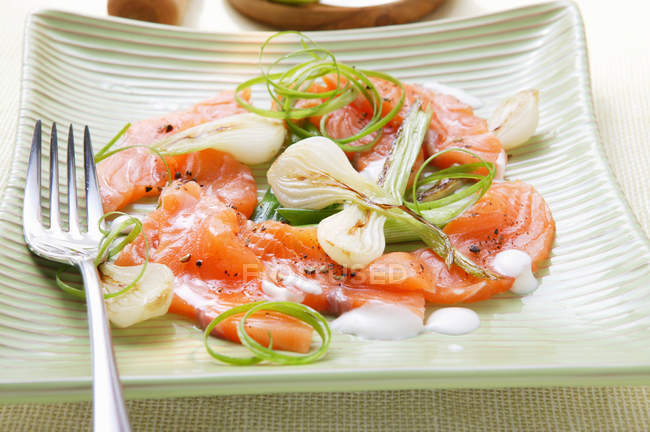 Salmon carpaccio with spring onions — Stock Photo