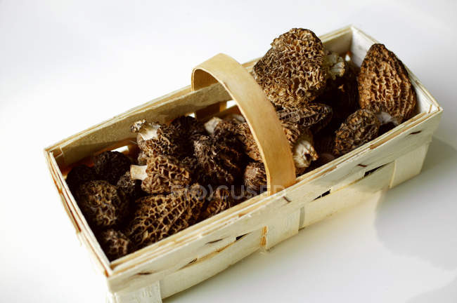 Elevated view of Morels in chip basket on white surface — Stock Photo