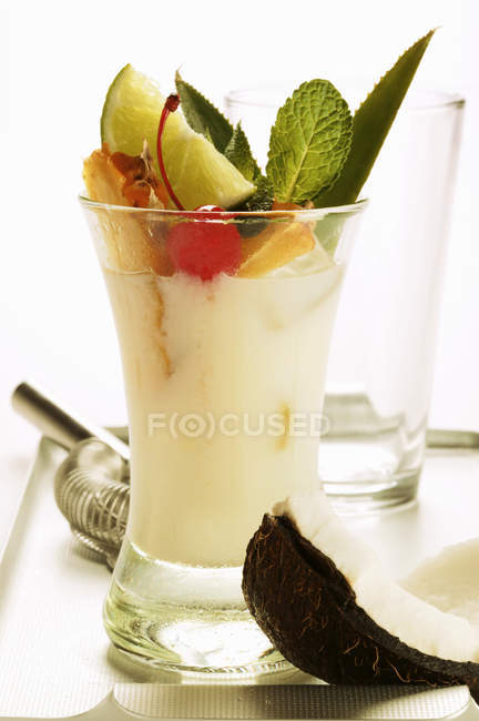 Vista de perto do cocktail Pina Colada com leite de coco, ervas e frutas — Fotografia de Stock
