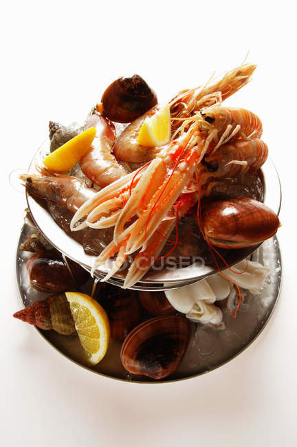 Closeup view of seafood and lemon wedges on tiered stand — Stock Photo