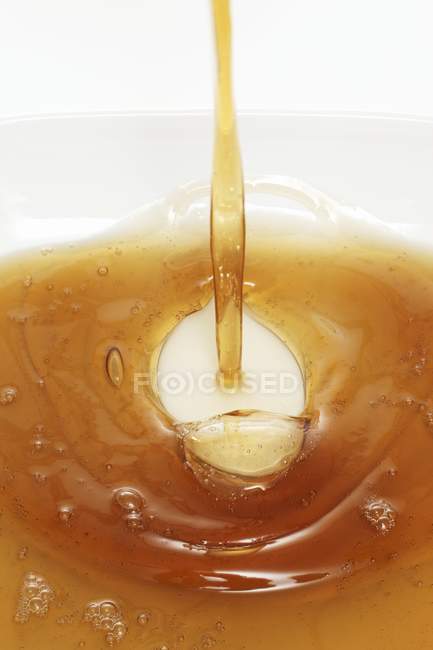 Closeup view of pouring fat to white dish — Stock Photo