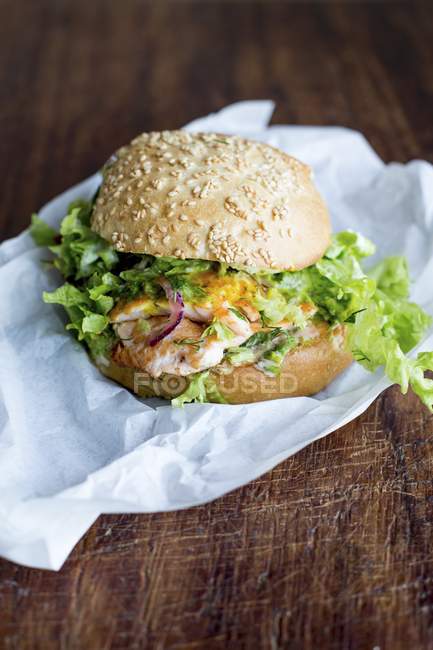 Бургер с лососем и зеленым салатом — стоковое фото