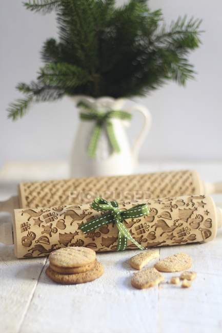 Closeup view of Christmas patterned rolling pins with cookies — Stock Photo