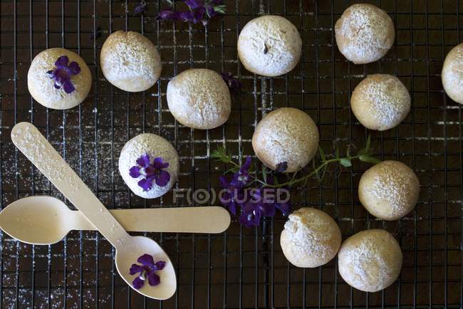Vue du dessus des biscuits à la cannelle sablés sur support de refroidissement avec violettes — Photo de stock