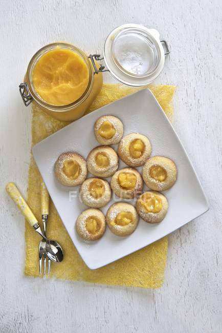 Top view of lemon cream cookies with jar of lemon curd — Stock Photo