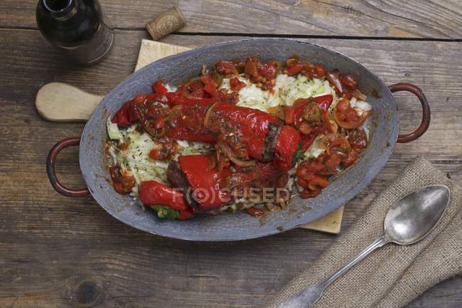Gefüllte rote Paprika auf grauem Teller über hölzerner Oberfläche — Stockfoto