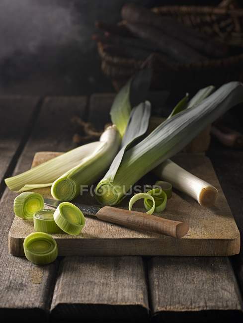 Leeks on wooden chopping board — Stock Photo
