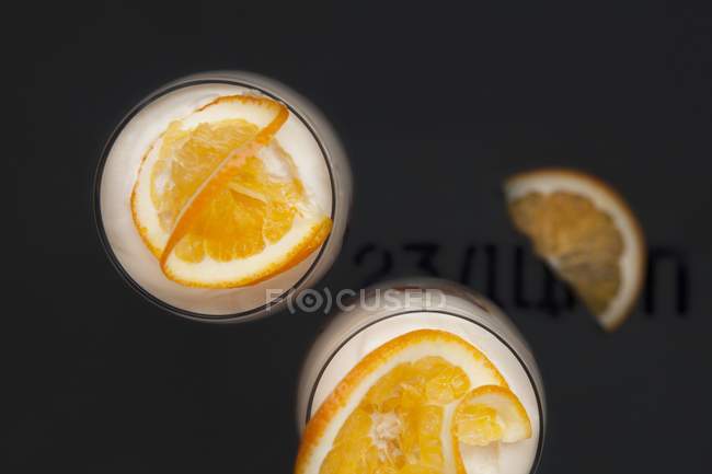 Primer plano vista superior de los postres de naranja en vasos - foto de stock