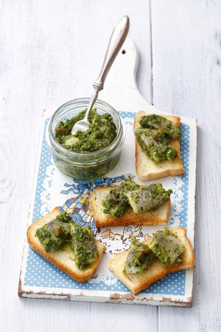 Elevated view of toasts topped with herring in Salsa Verde — Stock Photo