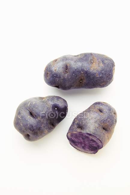 Raw and washed purple potatoes — Stock Photo