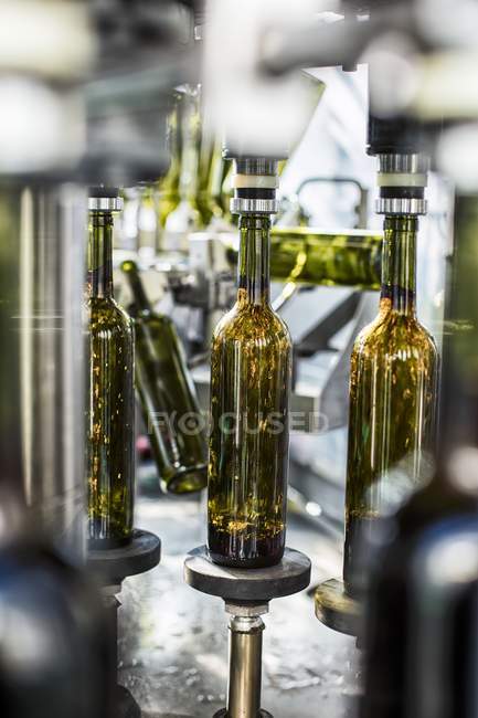 Vista close-up de derramar vinho em garrafas em uma planta de engarrafamento — Fotografia de Stock