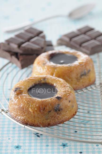 Closeup view of chocolate Financiers and bars on wire rack — Stock Photo