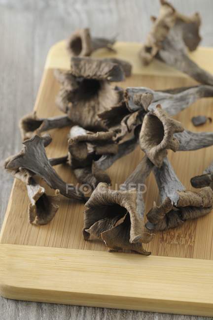 Chanterelles noires sur une planche en bois — Photo de stock