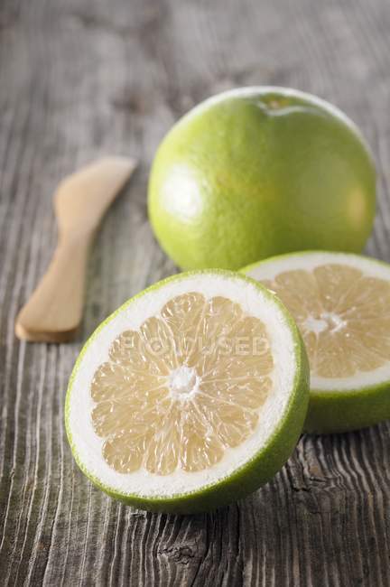 Fresh green grapefruit with halves — Stock Photo