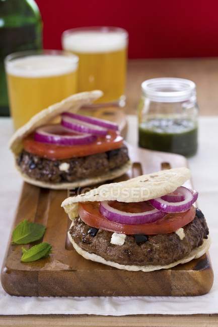 Greek-style lamb burger on wooden desk over cloth — Stock Photo